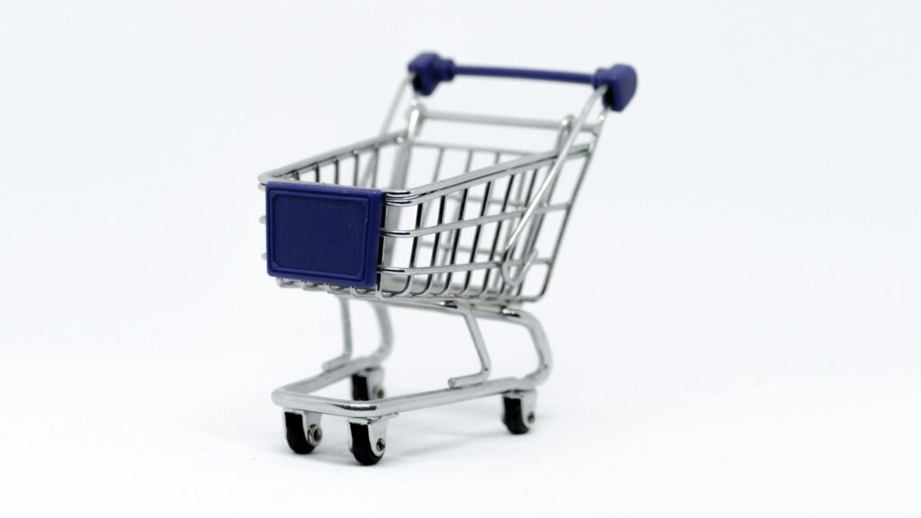 Mini shopping cart on white background symbolizing online shopping and e-commerce